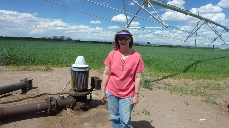 Karla Shriver stands by one of the many pivot sprinkler systems that she uses to irrigate her farm, just north of Alamosa. She irrigates her land with water from ditches and the aquifer, and is concerned about the depletion of the aquifer.