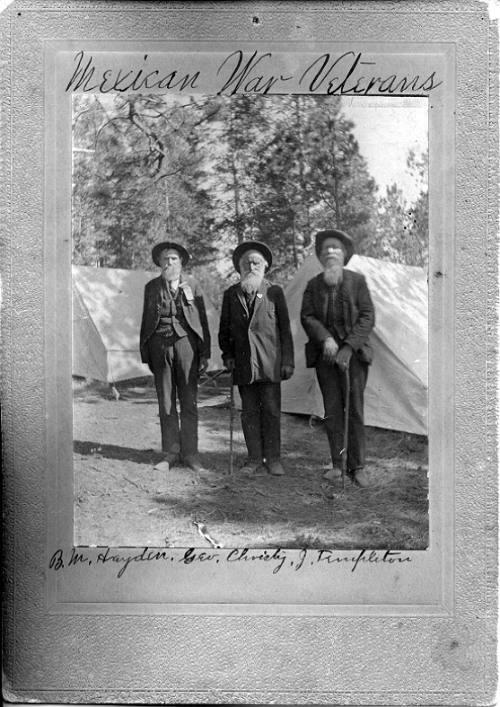Black and white photo of three men standing.