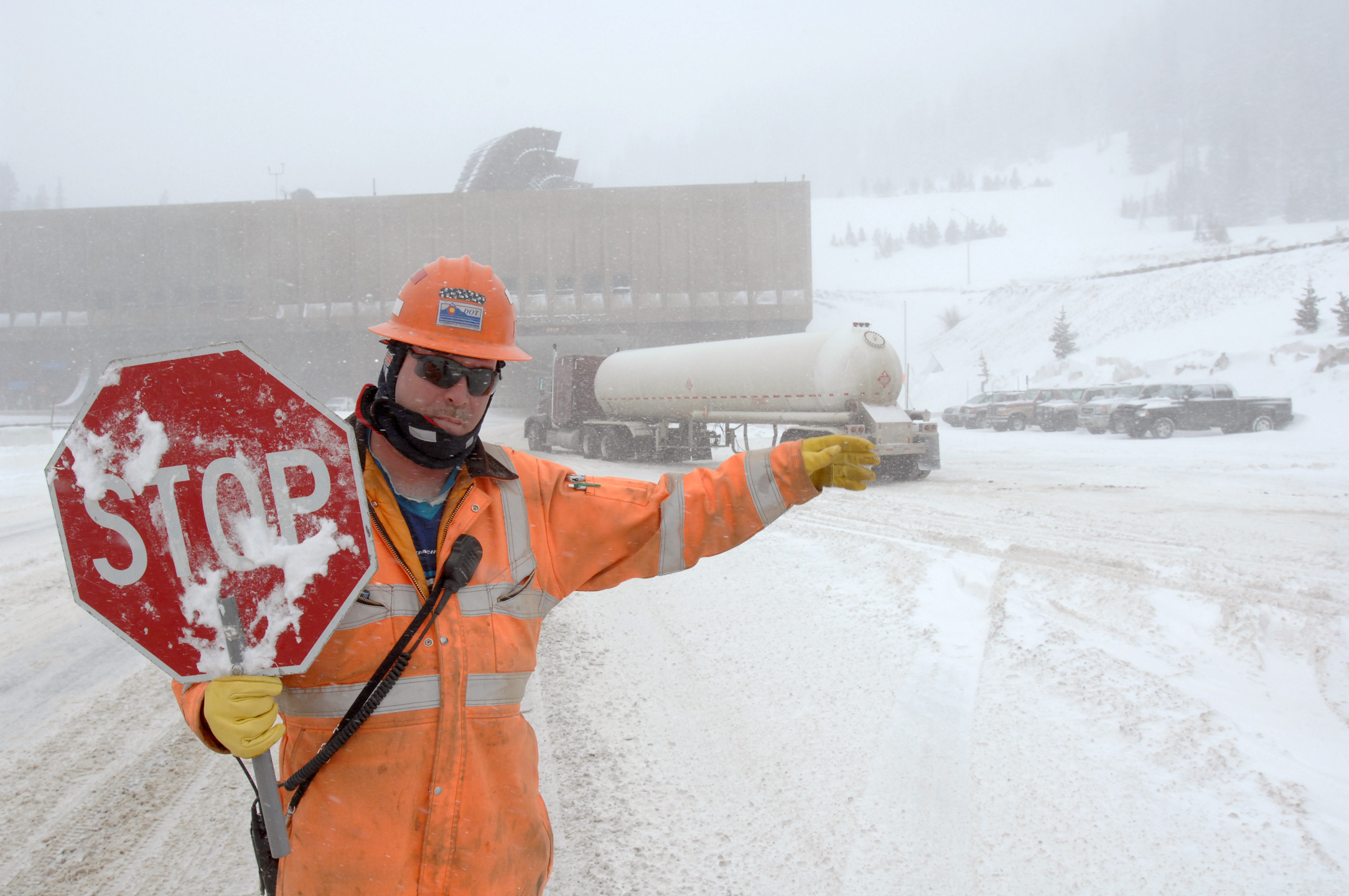 <p>Colorado Department Transportation worker George Fischer halts westbound Interstate 70 traffic at the east portal to the 11,300 foot Eisenhower Tunnel in a 2008 snowstorm to allow vehicles carrying hazardous materials through. High winds and blowing snows created dangerous conditions which closed Loveland Pass where hazmat vehicles usually travel.</p>