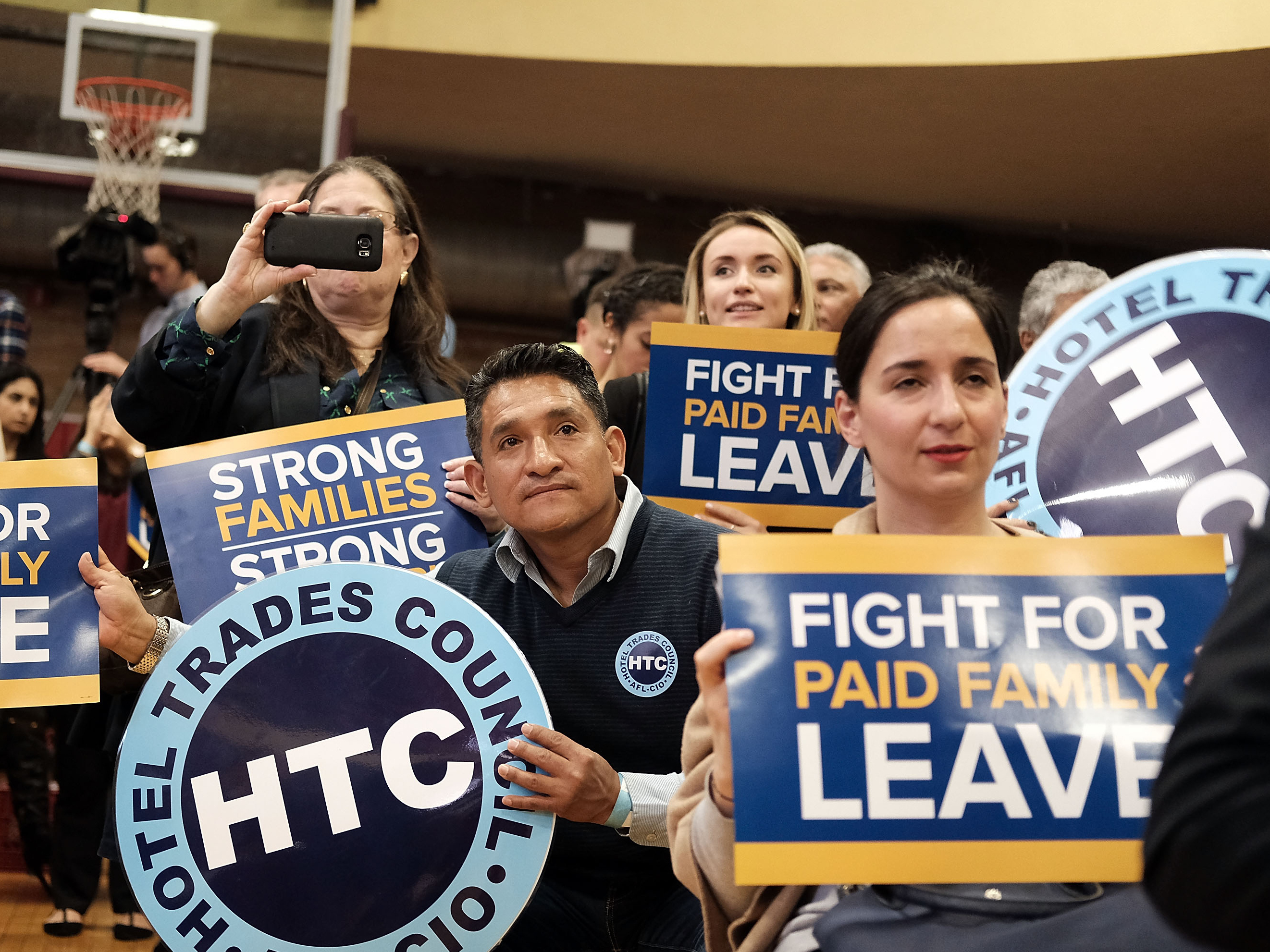 Supporters watch as New York Gov. Andrew Cuomo speaks to promote his paid family leave initiative at a rally in Manhattan on March 10.