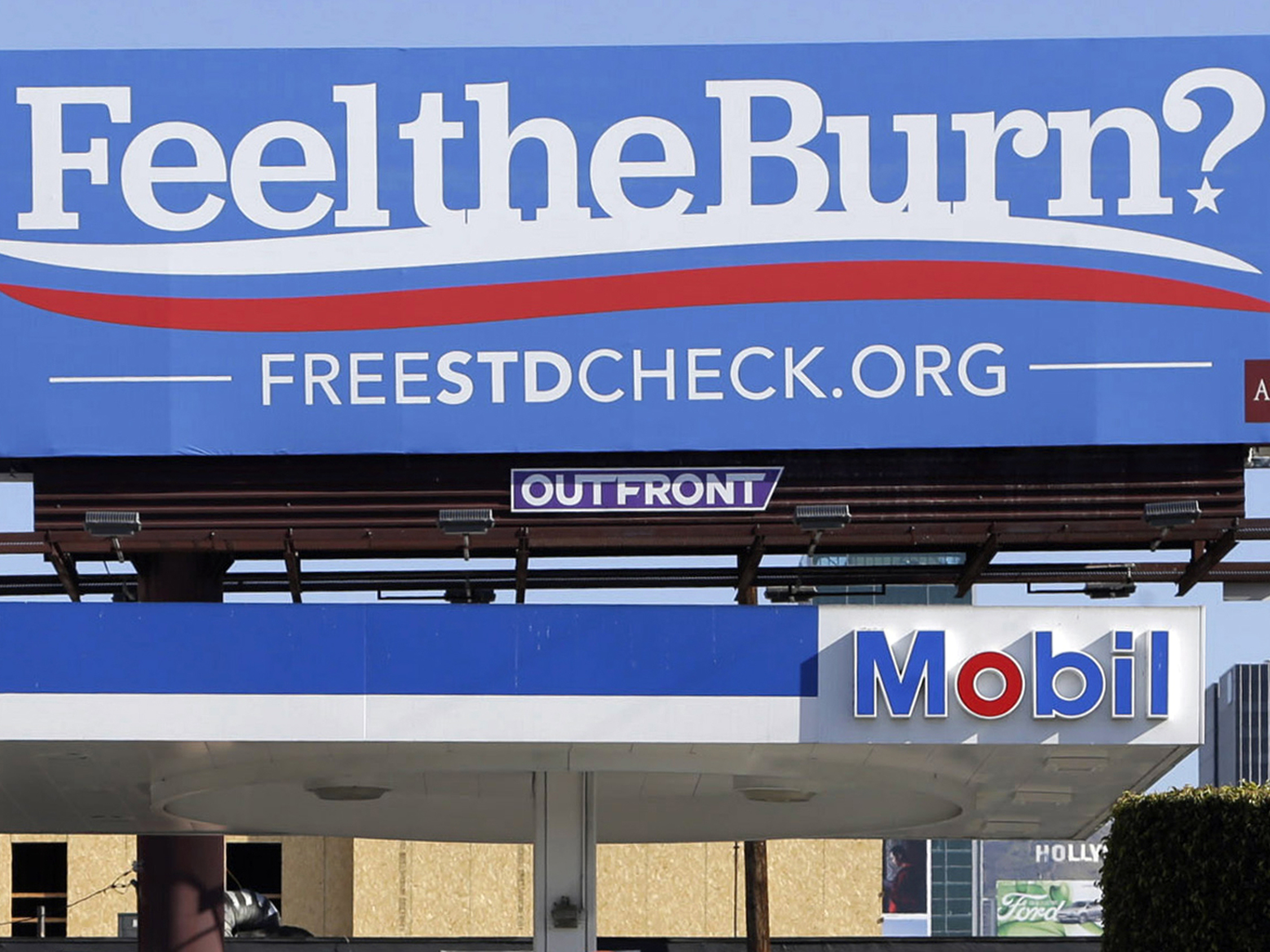 A billboard above a gas station reads “Feel The Burn,” a play on 2016