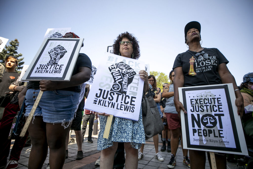 Protesters stand in a moment of silence for Kilyn Lewis