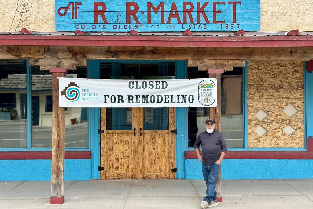A man stands outside of a building with a sign saying "Closed for Remodeling."