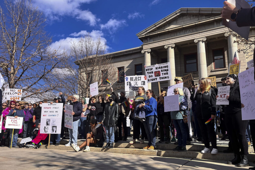 People holding signs gather outside