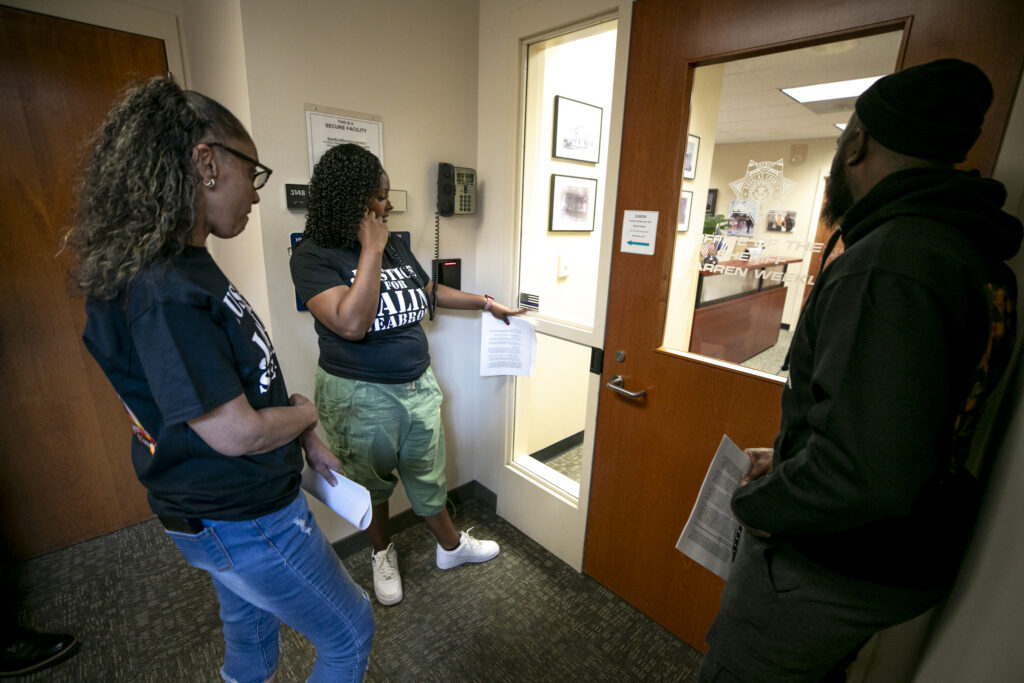 Veronica Seabron (from left), MiDian Shofner and Martinez Anderson attempt to speak with anyone at the Douglas County Sheriff office