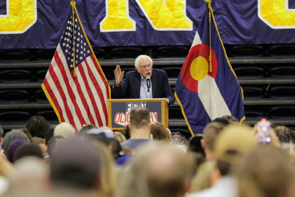 Bernie Sanders speaks from a podium that reads "Fight Oligarchy" at the Bank of Colorado Arena in Greeley