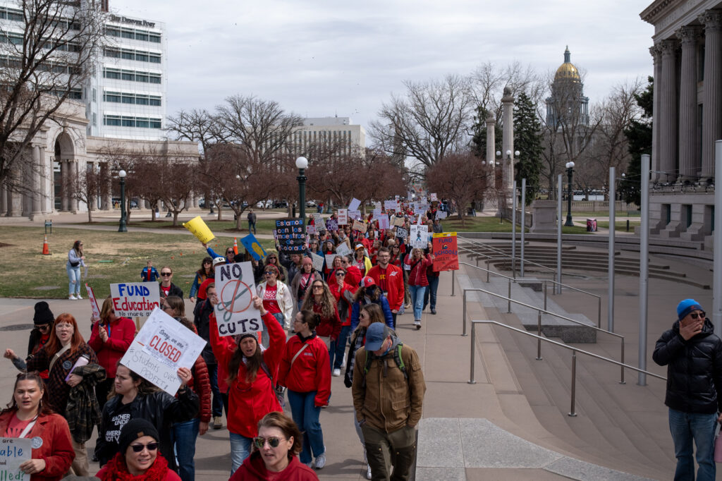 A stream of protesters wearing red walk away from the Capitol after the rally.