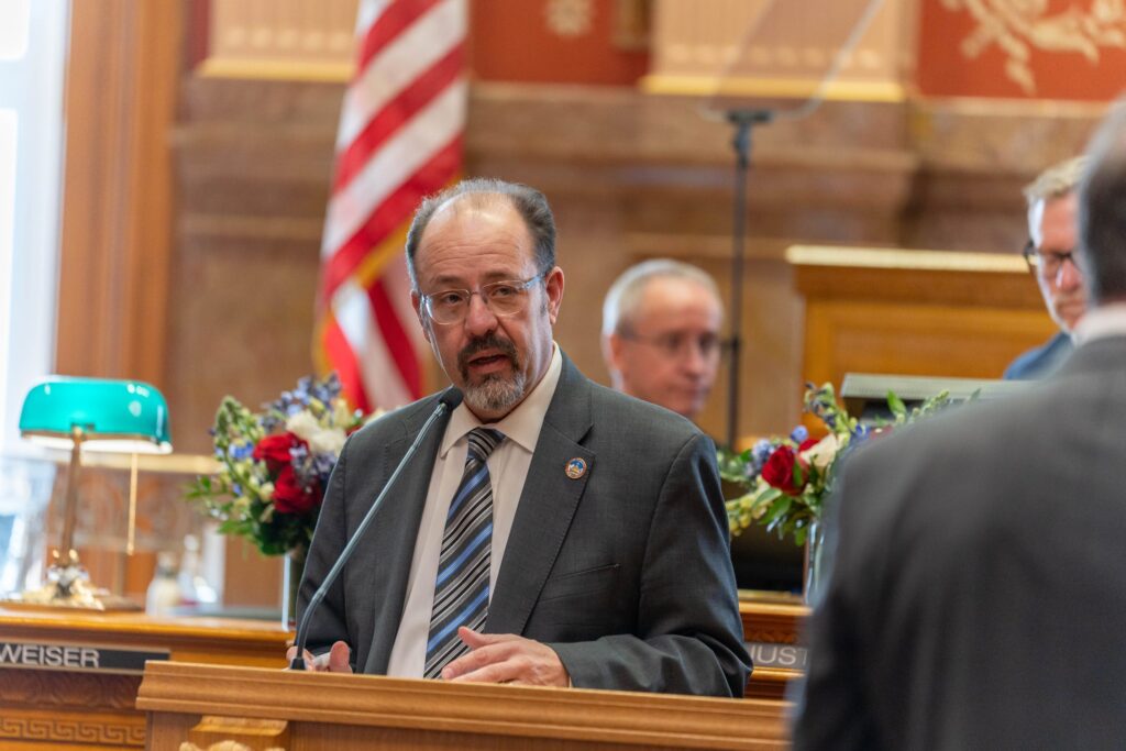 Sen. Robert Rodriguez stands at the lecturn at the front of the state Senate chambers