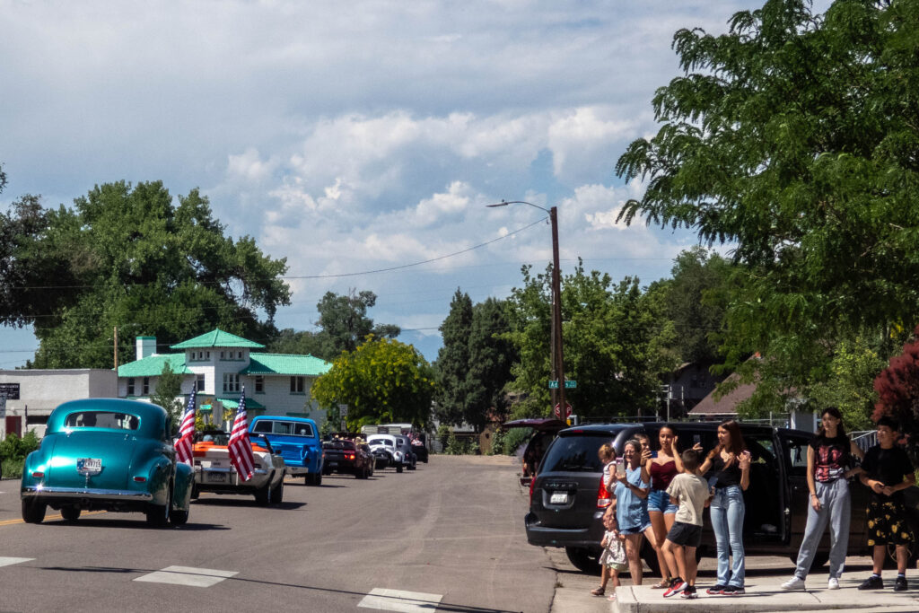 people watch parade of cars