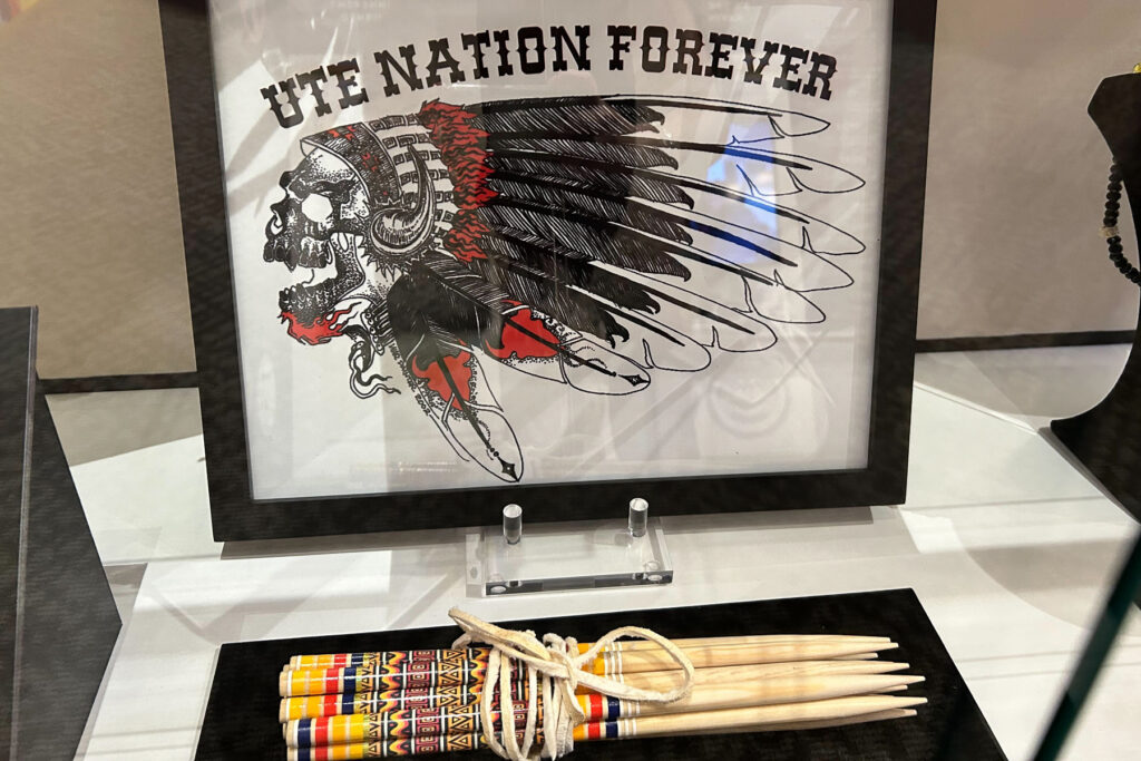 Photo shows a framed photo with a skull wearing a headdress with the saying "Ute Nation Forever" on display at the Pioneers Museum in Colorado Springs elevating Ute culture and history.