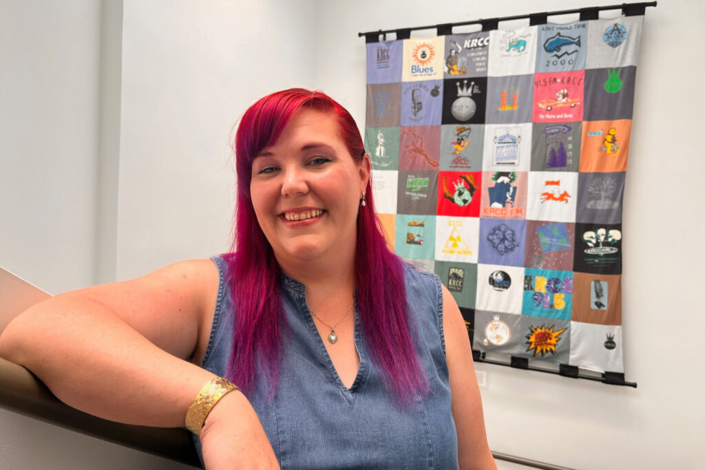 Woman stands in front of a quilt on a wall