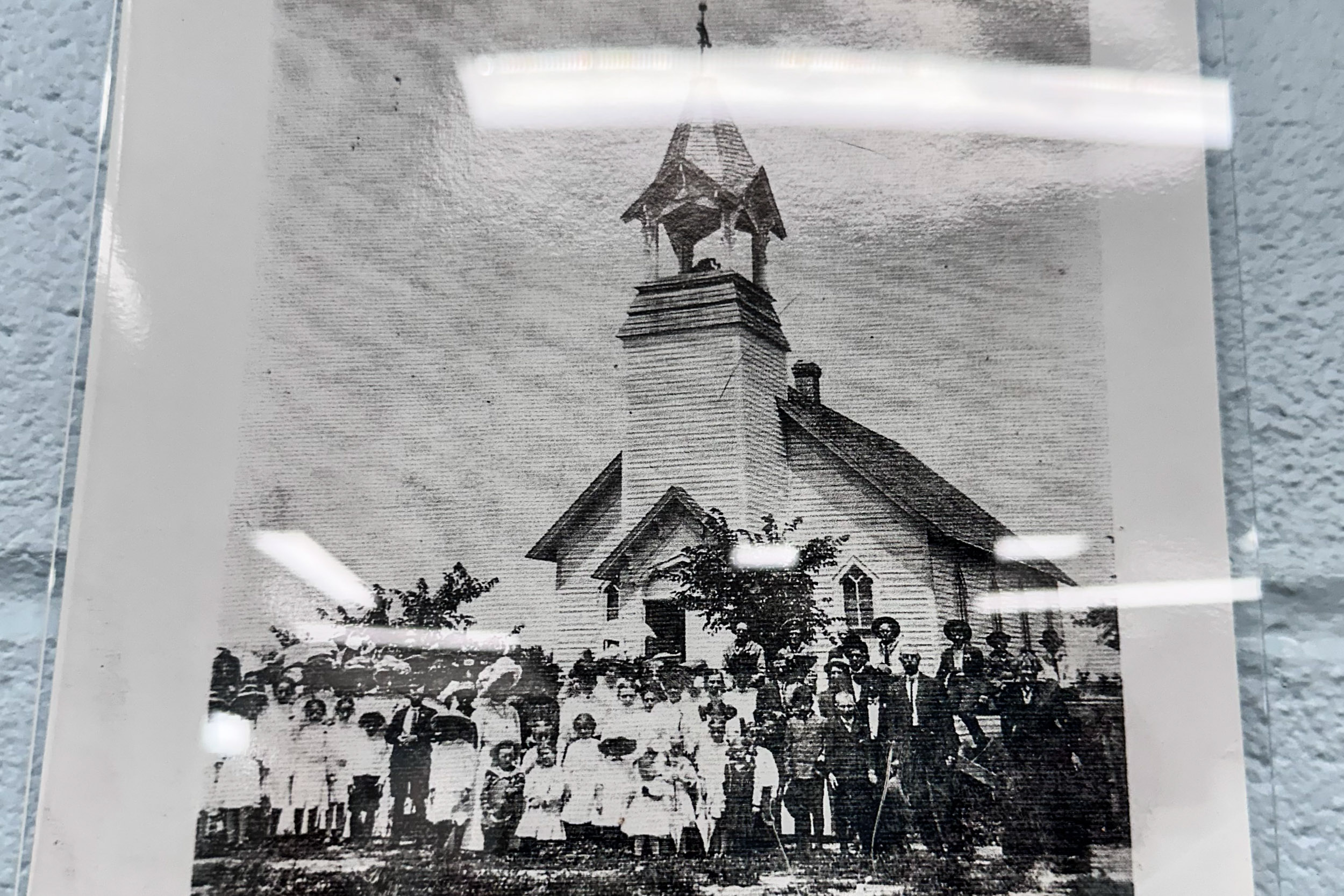 an old black and white photo of a church with people in front of it