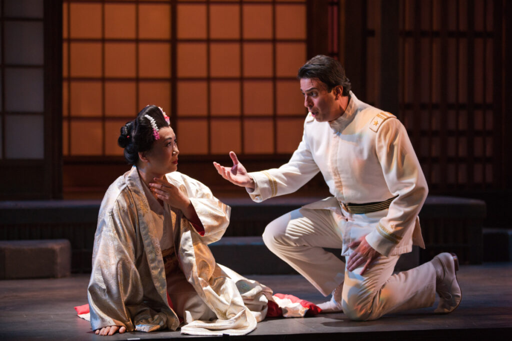 A man reaches out for a woman, who looks apprehansive about his intent.