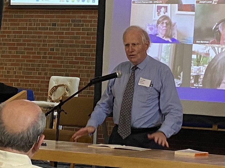A man dressed in blue shirt and tie gestures as he addresses a room of people interested in reforming America's health insurance system.