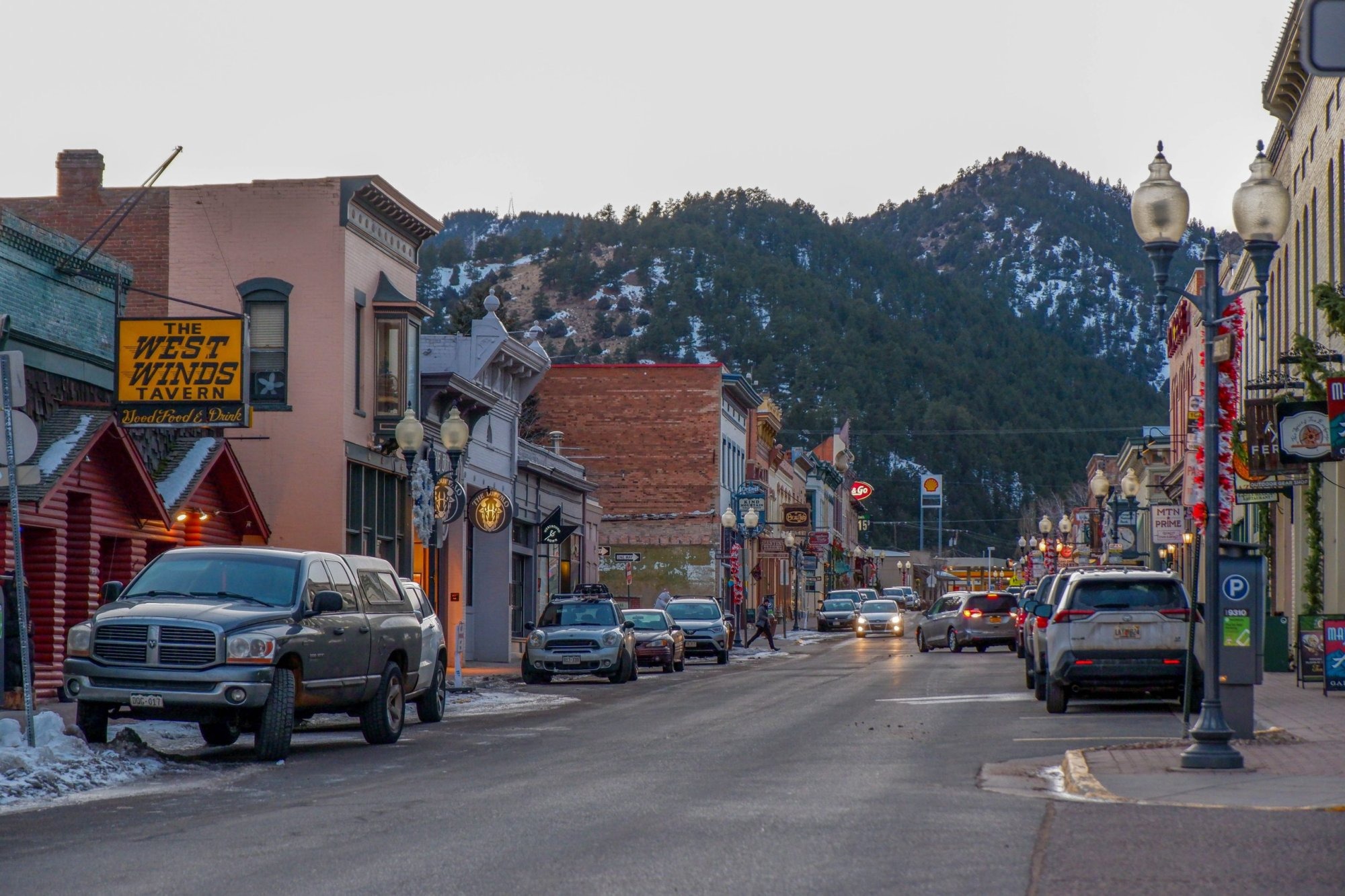 A road with buildings on either side mountains in the background