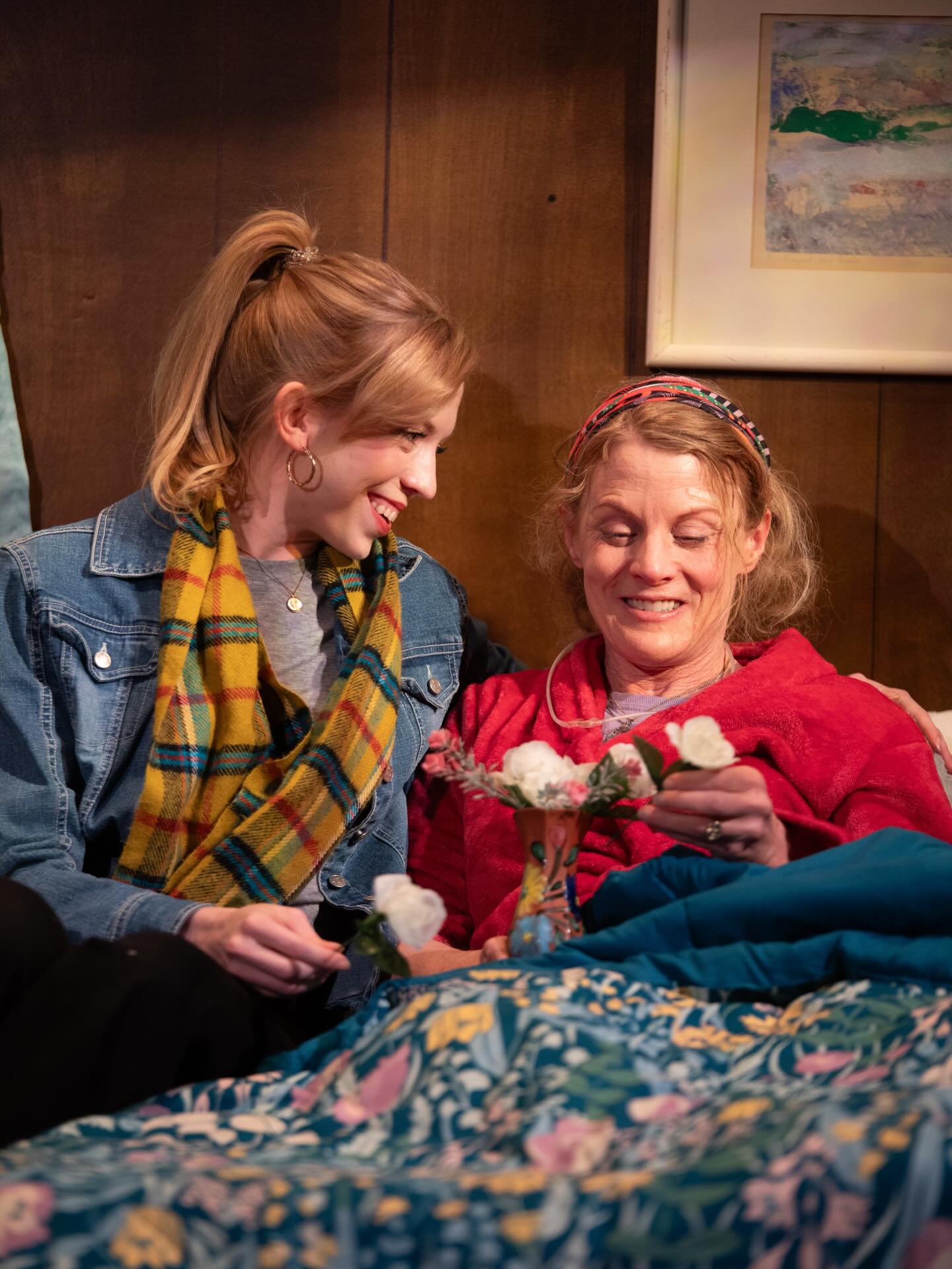 A woman smiles at another woman who's dear to her who has a breathing tube near her.